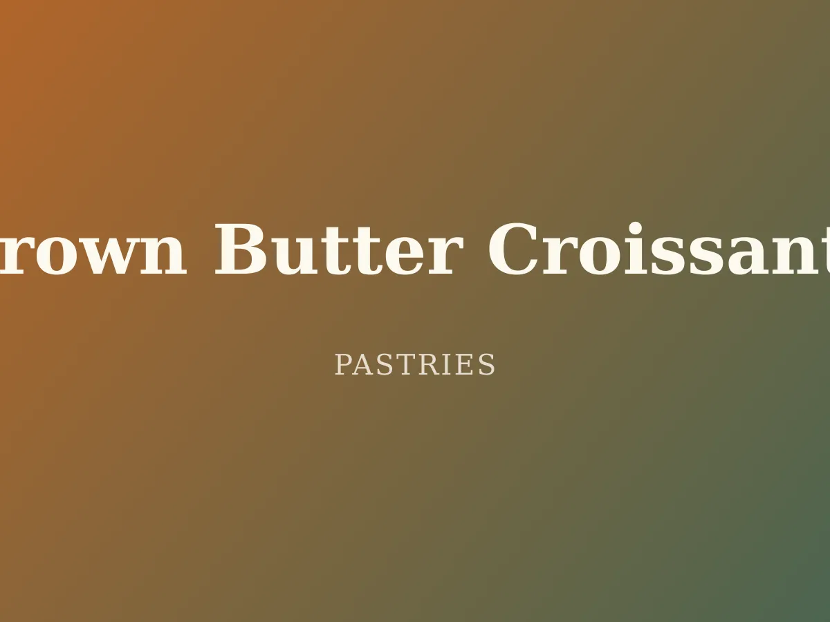 Brown Butter Croissants — a golden, flaky croissant with a honeycombed crumb visible at the torn end